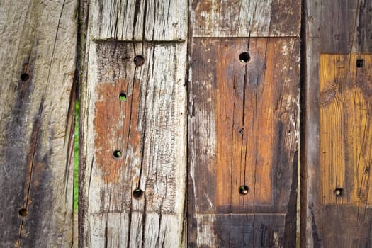 Background of rotting wooden planks with screw holes