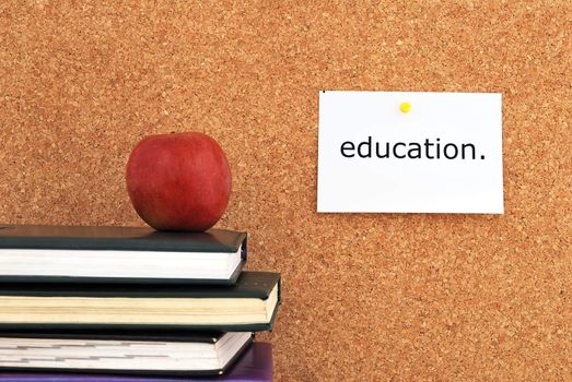 apple and books. against the background of the inscription cork board