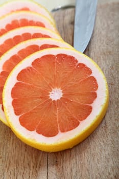 Fresh slices of pink grapefruit on a woodcutter