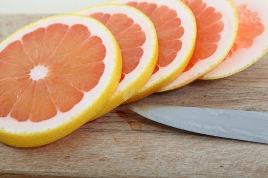 Fresh slices of pink grapefruit on a woodcutter