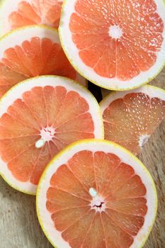 Fresh slices of pink grapefruit on a woodcutter