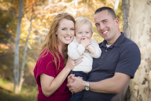 Young Attractive Parents and Child Portrait Outdoors.