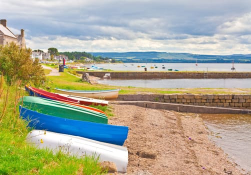 Small fishing boats moored o the edsge of the water at Findhorn, Scotland