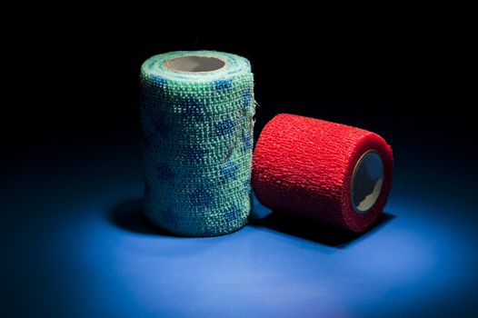 Two different colour medical bandages on studio floor