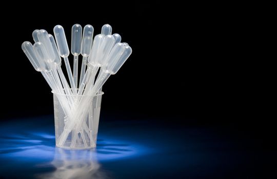 Pack of pipettes standing in glass in studio