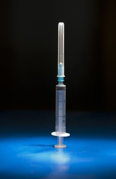 Empty and isolated medical syringe standing head up