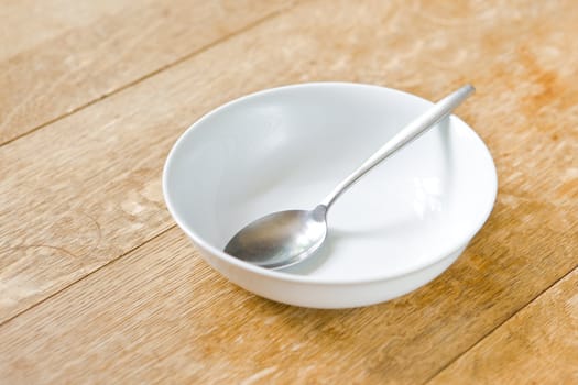 Breakfast bowl and spoon on a rustic wooden table top