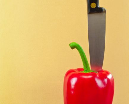 Knife cutting a red bell pepper