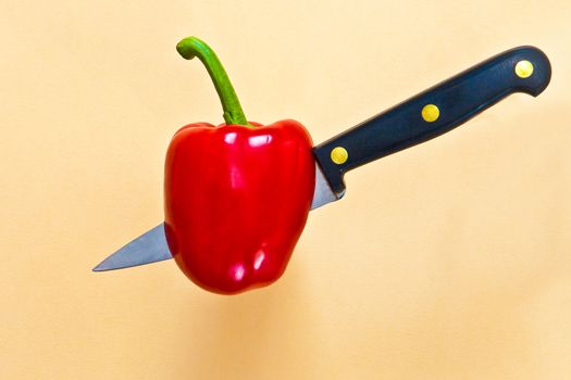 Red pepper being penetrated by a knife