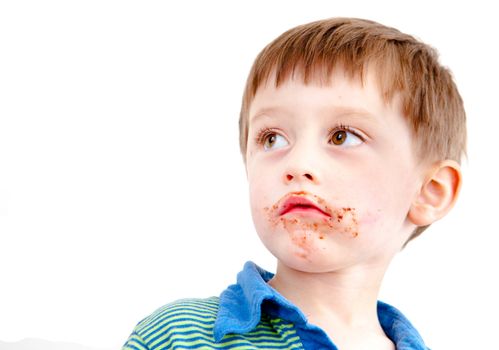 Young boy with chocolate on his face or ice cream isolated on white