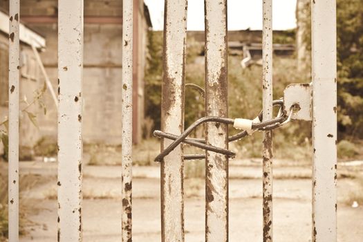 Close up of a locked gate to a scrapyard in vintage colours