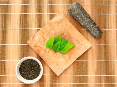 Mint leaves with a grinder and a bowl of mint sauce