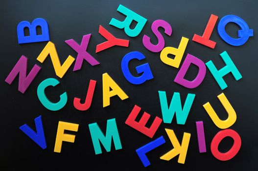 Random colorful letters put on a blackboard