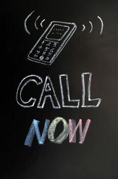 Call now - text written in chalk on a blackboard