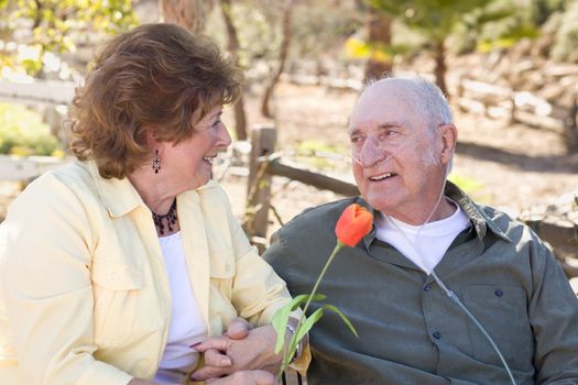 Senior Woman Outside with Seated Man Wearing Oxygen Tubes.