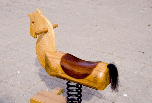 Swing wooden horse toy for kids carved out of wood. Spring and tail.