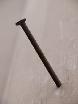 Rusty nail in wood wall.