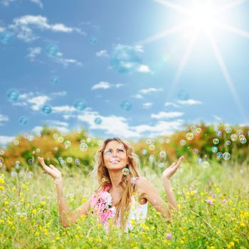  Blonde starts soap bubbles in a green field