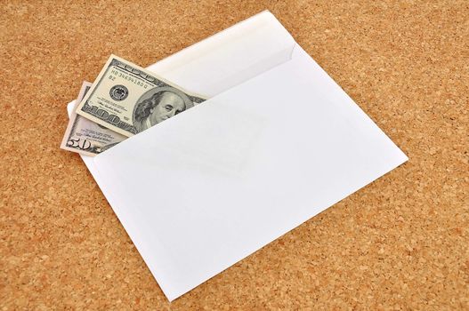 dollars in an envelope on the cork background