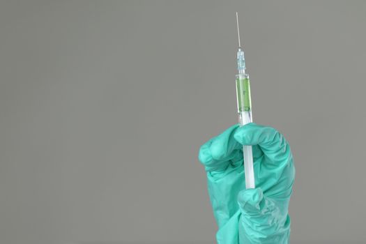 syringe in hand on gray background