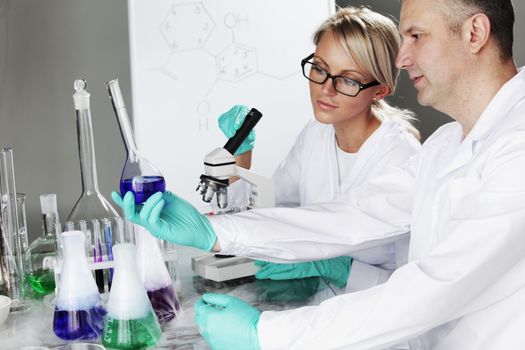 two scientist in chemical lab conducting experiments