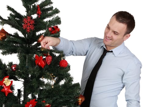 A young man decorating a Christmas tree isolated against a white background.