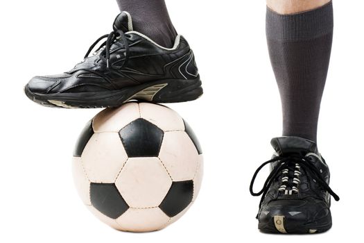 Foot on black white football or soccer sport ball