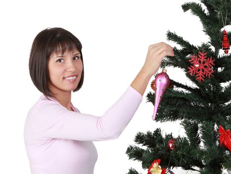 Image of a young brunette woman decorating the Christmas tree isolated against a white background.