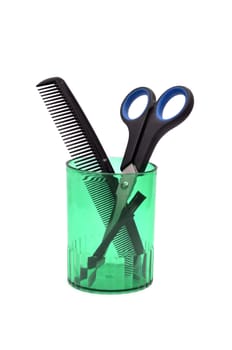 comb and scissors and a glass on a white background