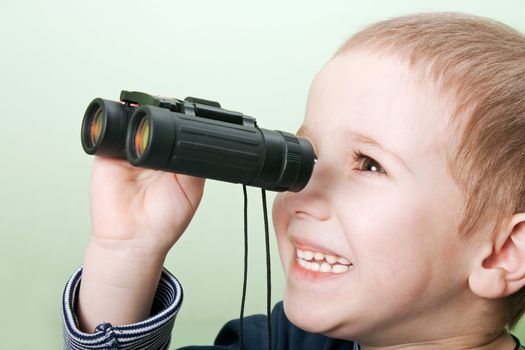 Little child boy looking binoculars lens isolated