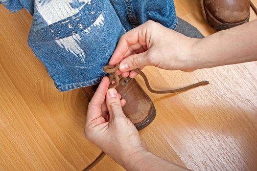 Person tying little child boy foot sport shoe lace