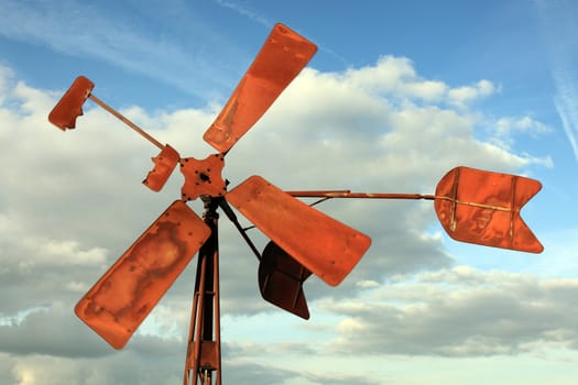 Broken and rusty windmill pumping water in a polder in Holland