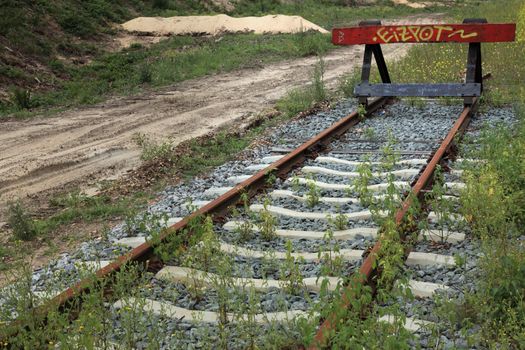 buffer stop at end of overgrown railroad