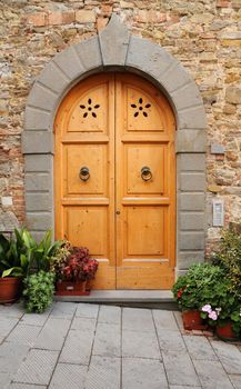 typical wooden door framed with stone arch in Tuscany, Italy, Europe
