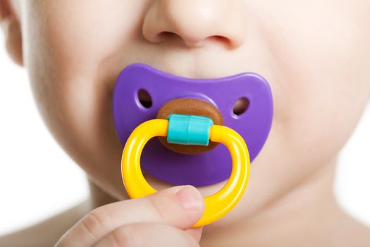 Little child boy and plastic baby soother pacifier