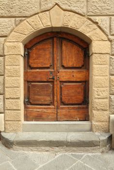 elegant tuscan wooden door framed with stone arc, Tuscany, Italy,Europe