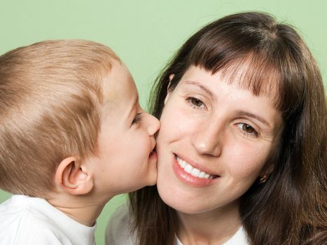 Child kissing smiling mother - family happiness