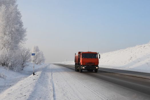 Red dump truck on winter road