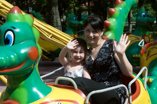 Mother with little girl on carousel