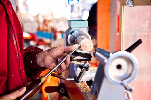 Old worker hands at lathe