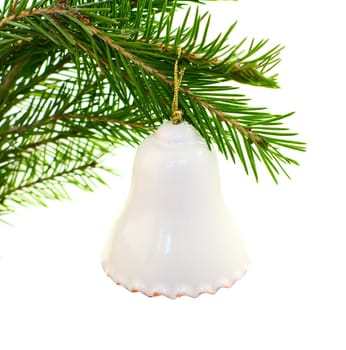  white ceramic bell hangs on green fir branch 
