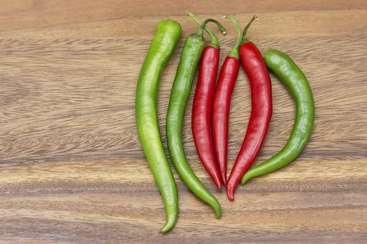 Red hot chili peppers over wooden background 
