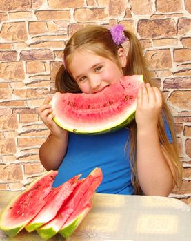 smiling girl holds piece of melon and eats it