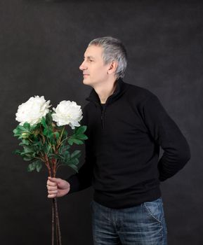 Man holding a bouquet of flowers on gray background