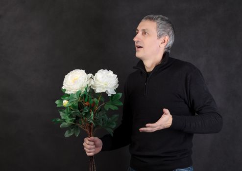 Man holding a bouquet of flowers on gray background