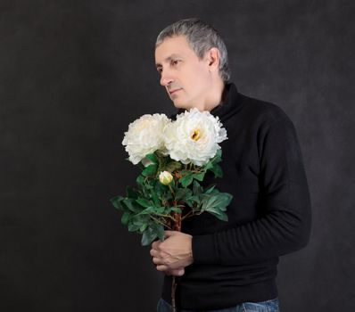 Man holding a bouquet of flowers on gray background