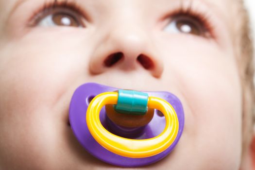 Little child boy and plastic baby soother pacifier