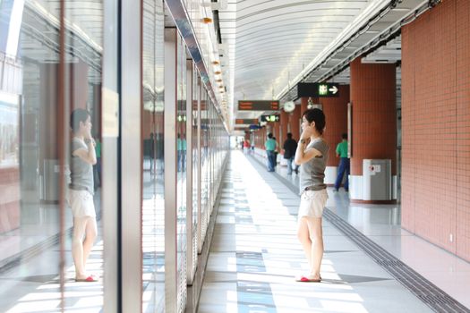 Asian girl waiting in train station