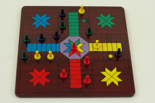 Parcheesi board with a game in progress of four players.