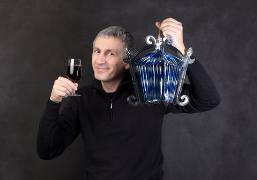 Man holding a glass wine and lantern, on gray background